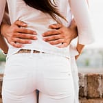young couple holding each other around waist being close
